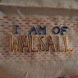"I Am Of Walsall" embroidered in multicoloured thread on tabby weave linen