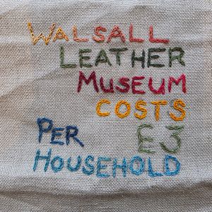 "Walsall Leather Museum costs £3 per household" embroidered in multicoloured thread on tabby weave linen