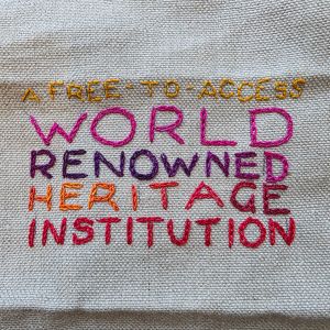 "A Free-To-Access World Renowned Heritage Institution" embroidered in multicoloured thread on tabby weave linen